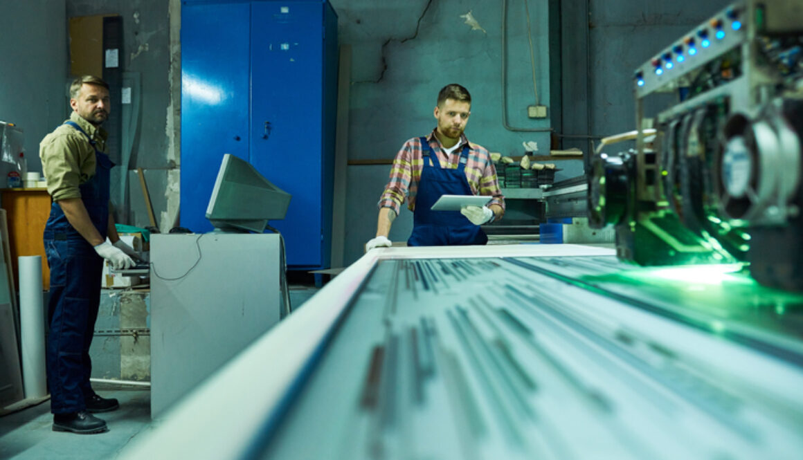 Workers Operating Laser Engraving Unit at Factory