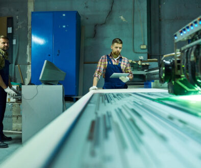 Workers Operating Laser Engraving Unit at Factory