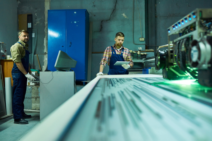 Workers Operating Laser Engraving Unit at Factory