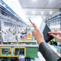 woman with ipad overseeing operations in warehouse