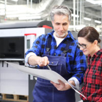 man and woman analyzing printed paper