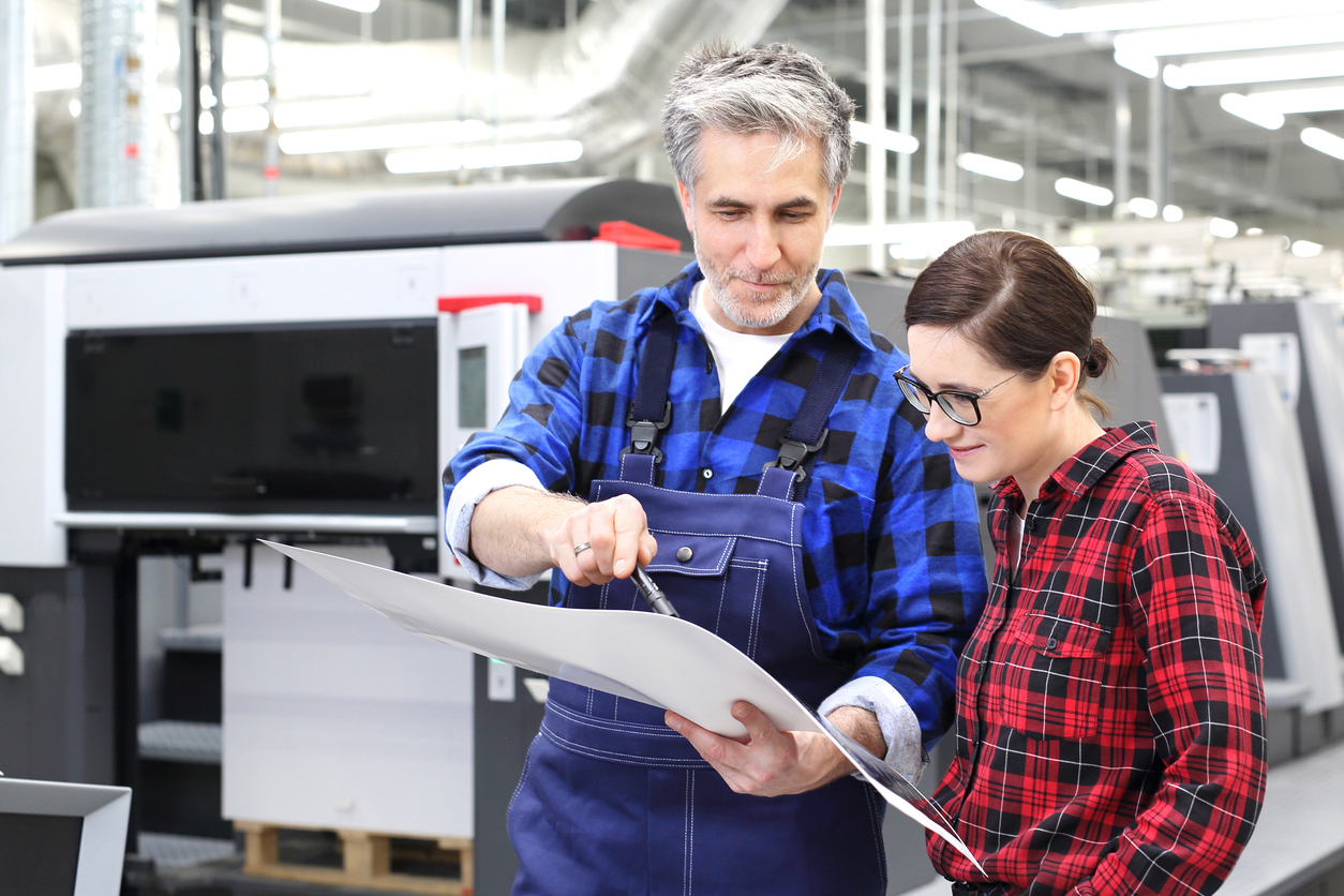 man and woman analyzing printed paper