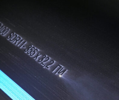 Laser Marking Machine Engraving. Manufacture of plastic water pipes of the factory. Process of making plastic tubes on the machine tool with the use of water and air pressure.